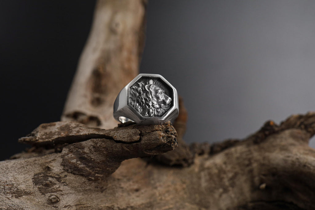 African lion signet ring, sterling silver safari animal jewelry, symbolic king lion statement band, and handcrafted bold accessory designed for those who are drawn to courage, leadership, and untamed strength. This striking ring features a detailed African lion motif framed within a bold signet structure, creating a look that feels regal, masculine, and deeply symbolic