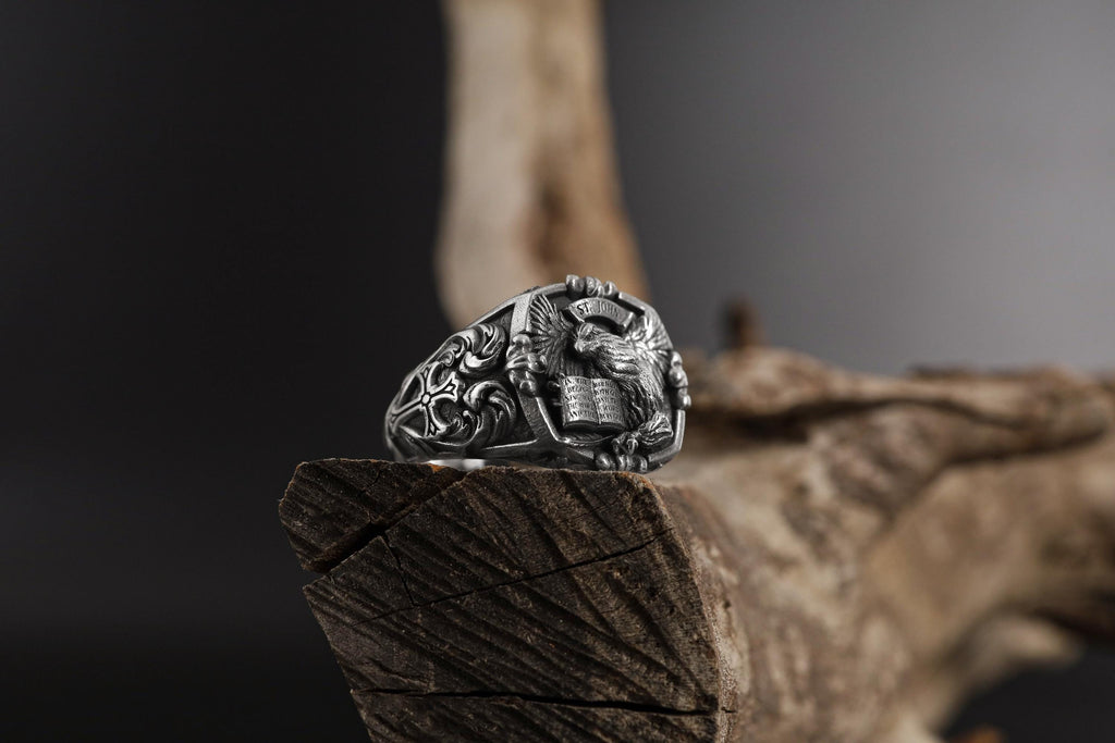 St. John eagle signet ring, sterling silver Christian jewelry, symbolic religious statement band, and handcrafted bold accessory designed for those who are drawn to faith, wisdom, and spiritual strength. This striking ring features a detailed eagle motif inspired by Saint John symbolism, framed within a bold signet structure that creates a look both sacred and powerful.