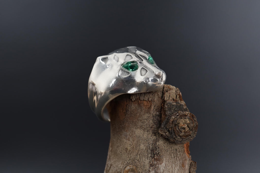 Emerald eyes leopard head ring, panther inspired statement jewelry, symbolic big cat signet band, and handcrafted bold accessory designed for those who are drawn to power, confidence, and fierce elegance. This striking ring features a detailed leopard head motif with vivid emerald stone eyes, creating a luxurious and commanding appearance inspired by wild feline strength and timeless masculine style.
